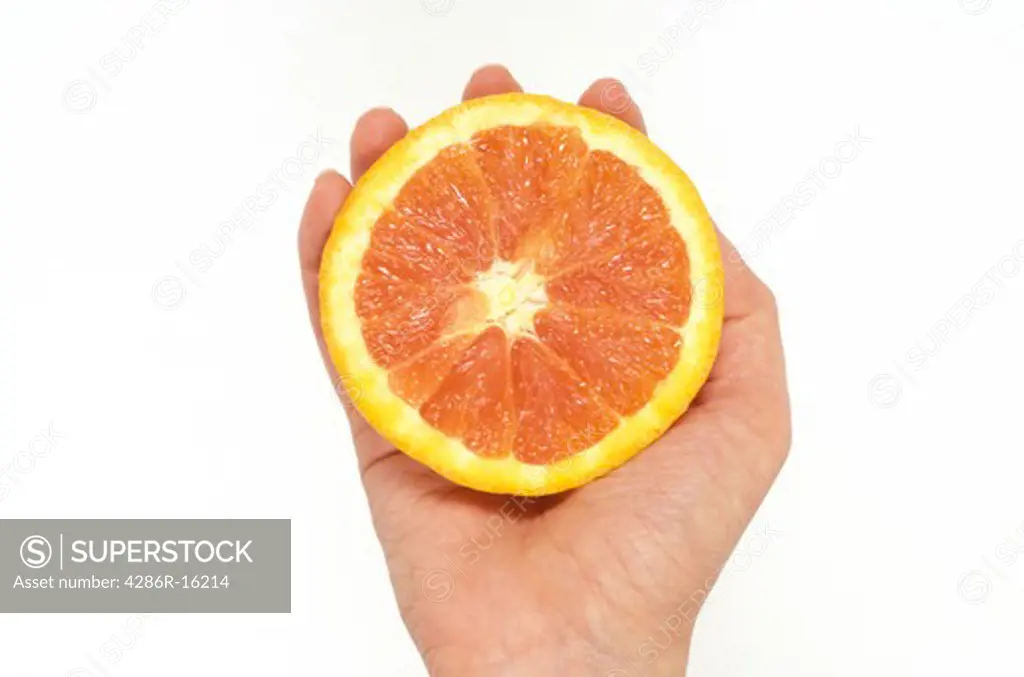Hand holding grapefruit, close up