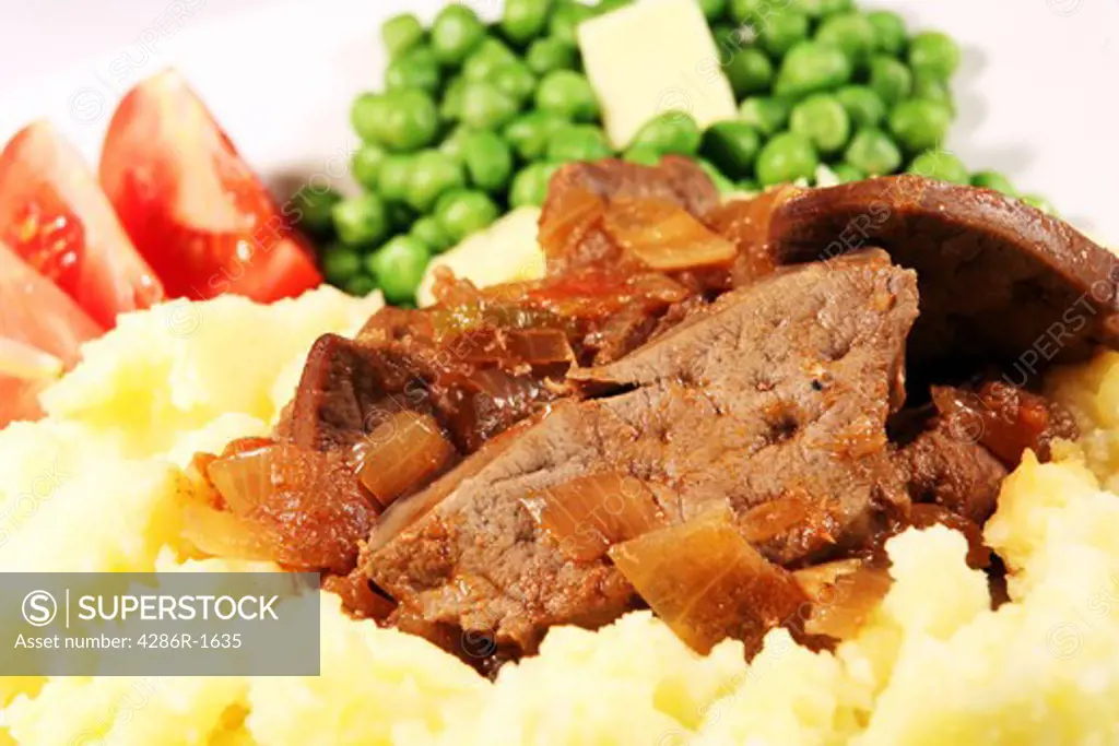 Stewed liver and onions, served on a bed of mashed potato with tomato and peas
