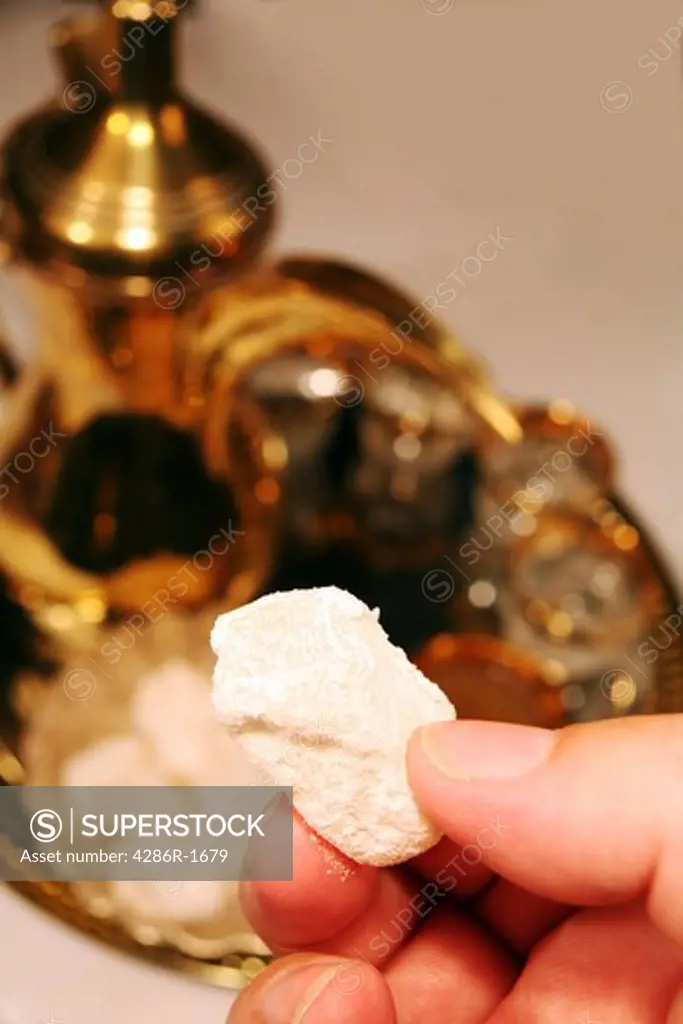 Breaking the Ramadan fast with a piece of Turkish delight (raha haloum). A coffee pot and glasses are in the background.