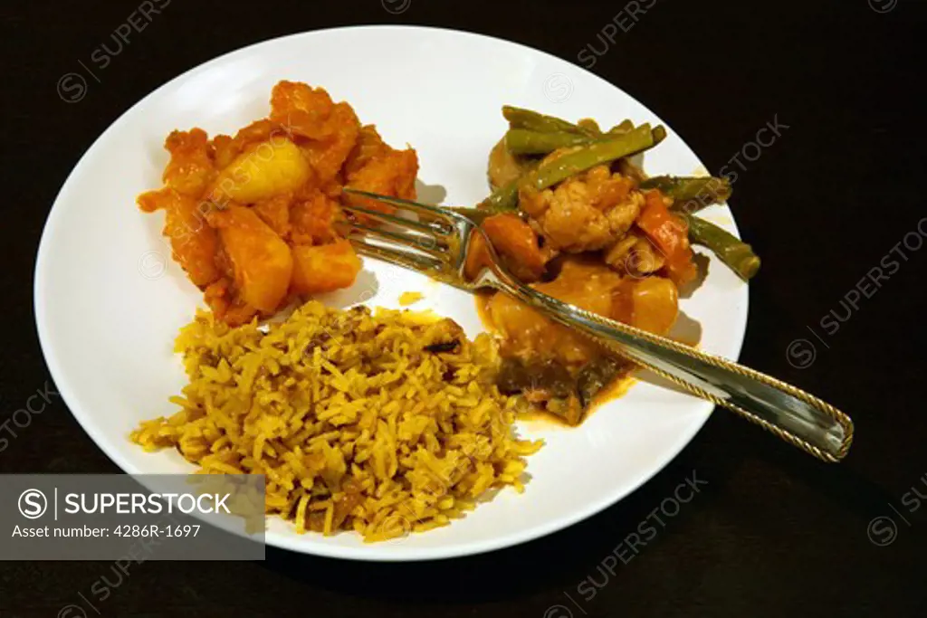 A vegetarian curry dinner, with Punjabi potato curry, vegetable curry and pilau rice.