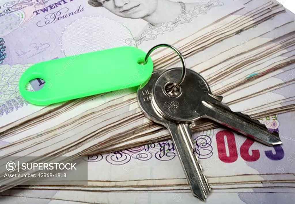 A set of house keys resting on a big pile of used 20 pound notes - perhaps a rent or mortgage payment or deposit... or the keys to success