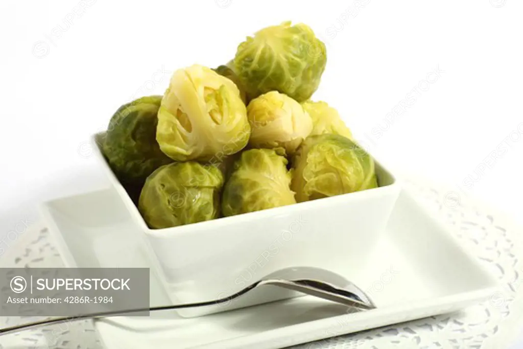 A bowl of brussels sprouts, with a serving spoon