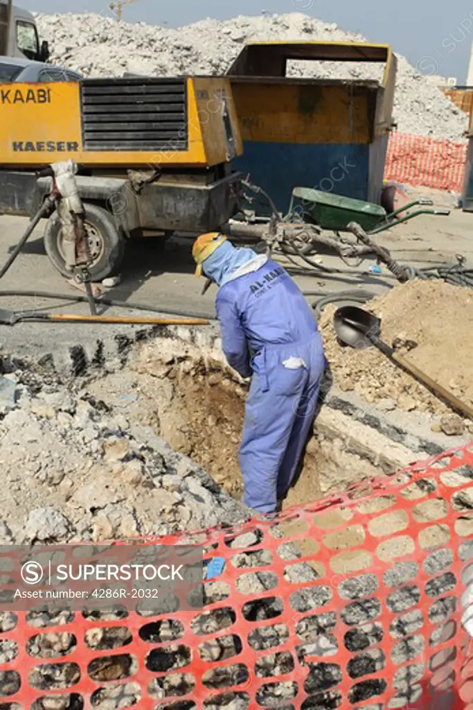 A labourer at work in a trench during the demolition of the centre of Doha, Qatar, ahead of a major redevelopment scheme