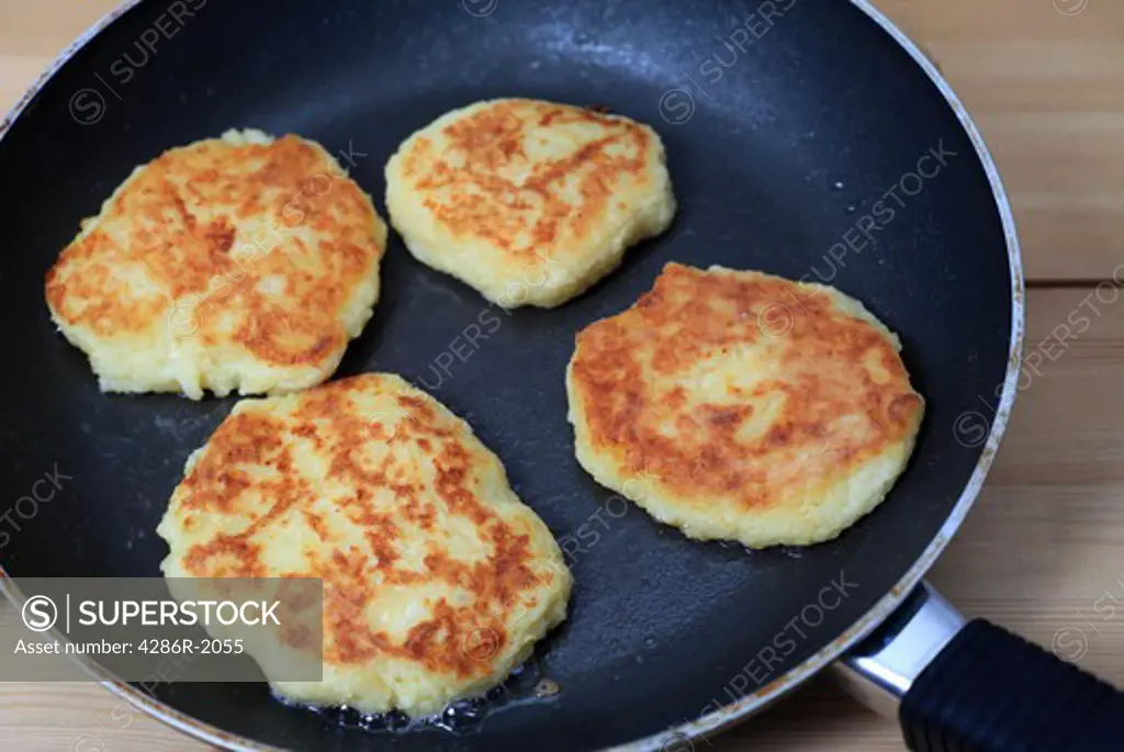 Potato pancakes cooking in a frying pan