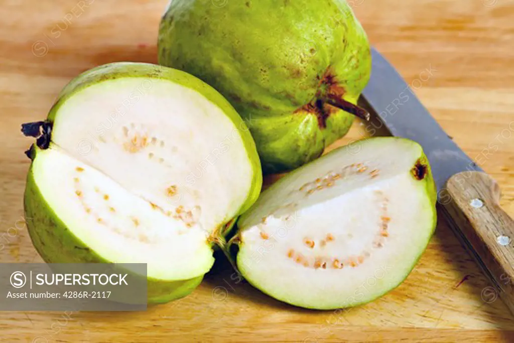 A guava fruit, of the common apple guava (Psidium guajava) variety, cut open to show the flesh and pips inside