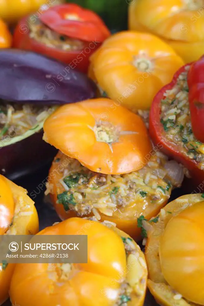 Oven ready traditional Greek-style stuffed vegetables, with yellow and red tomatoes and an aubergine. The rice, meat, parsley and onion filling is pre-cooked.