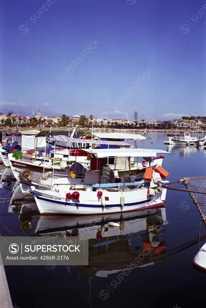 Fishing boats tied up in the harbour at Rethymnon, June 2009, with the town behind. Medium format film photo.