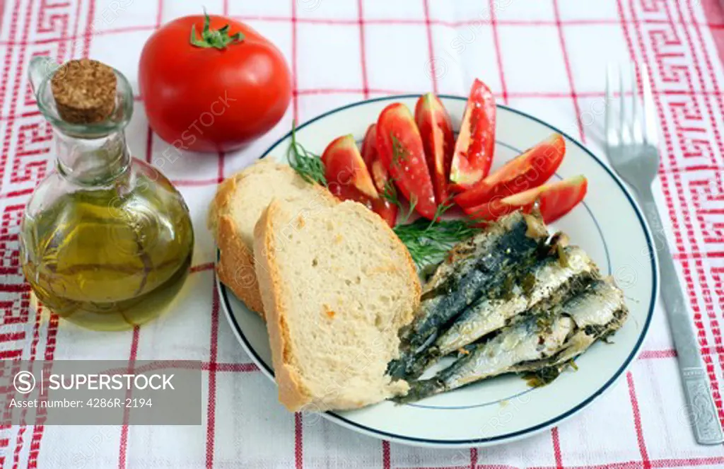 A meal of baked fresh sardines with bread, tomatoes and olive oil, an extremely healthy dish, high in Vitamin D, co-enzyme Q10 and Omega-3 oils