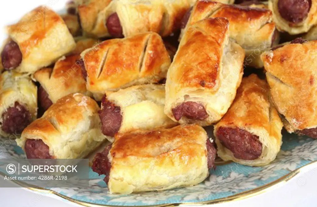 Close-up view of homemade sausage rolls on a fancy plate.