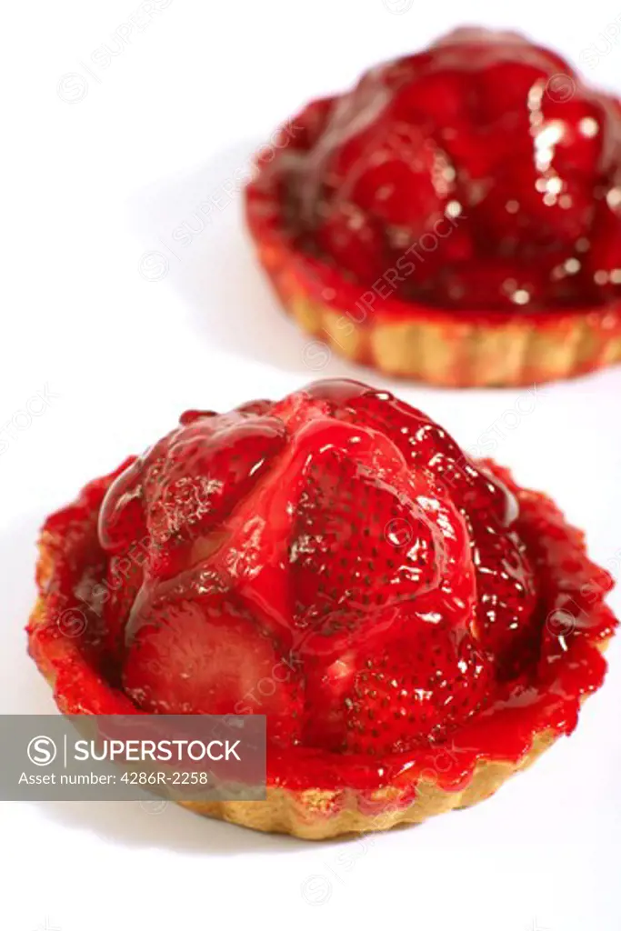Two strawberry tarts on a white background