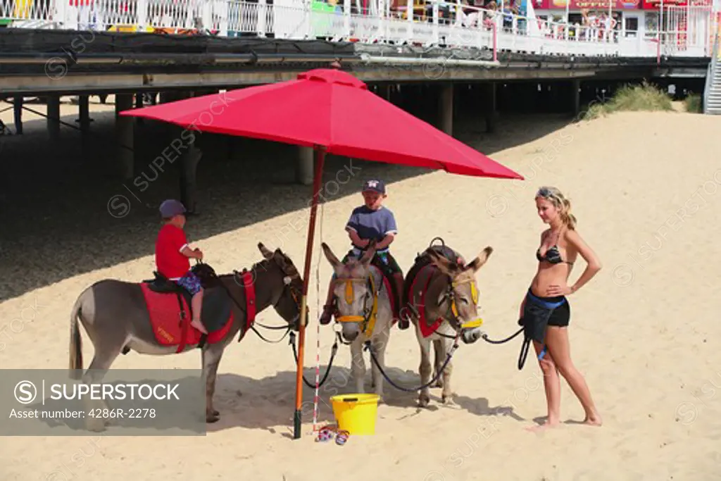 Children get ready for a donkey ride on the beach at Great Yarmouth, Norfolk, England