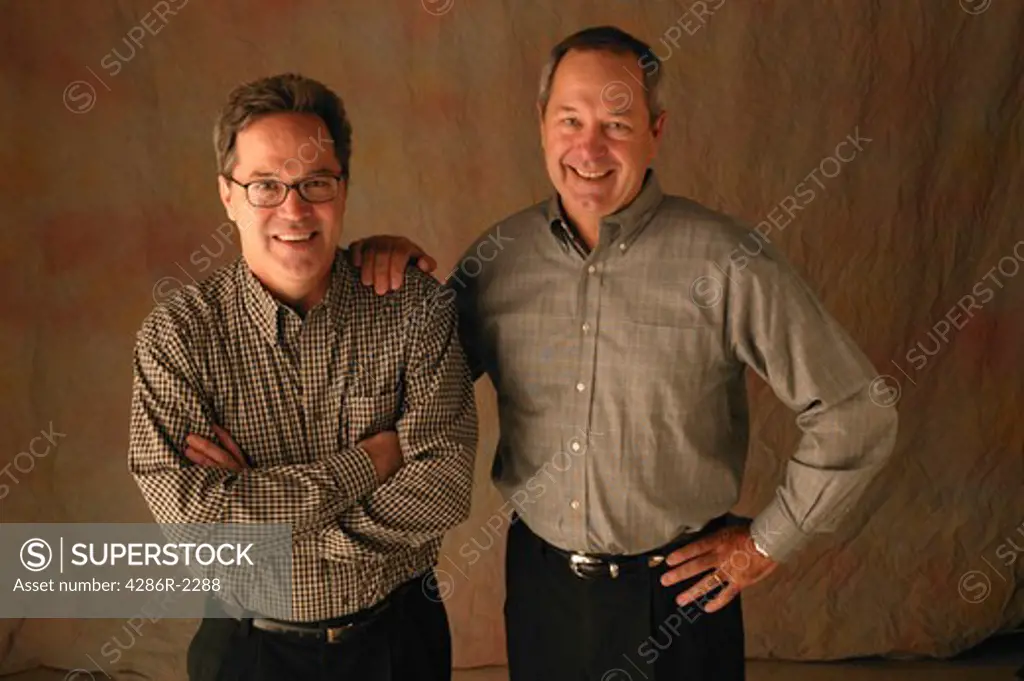 Studio shot of two casually dressed, smiling men.