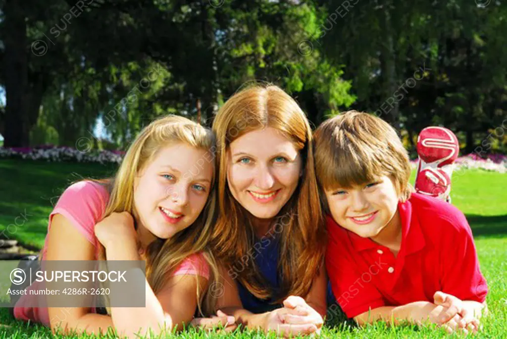 Portrait of a family - mother and children - relaxing in summer park