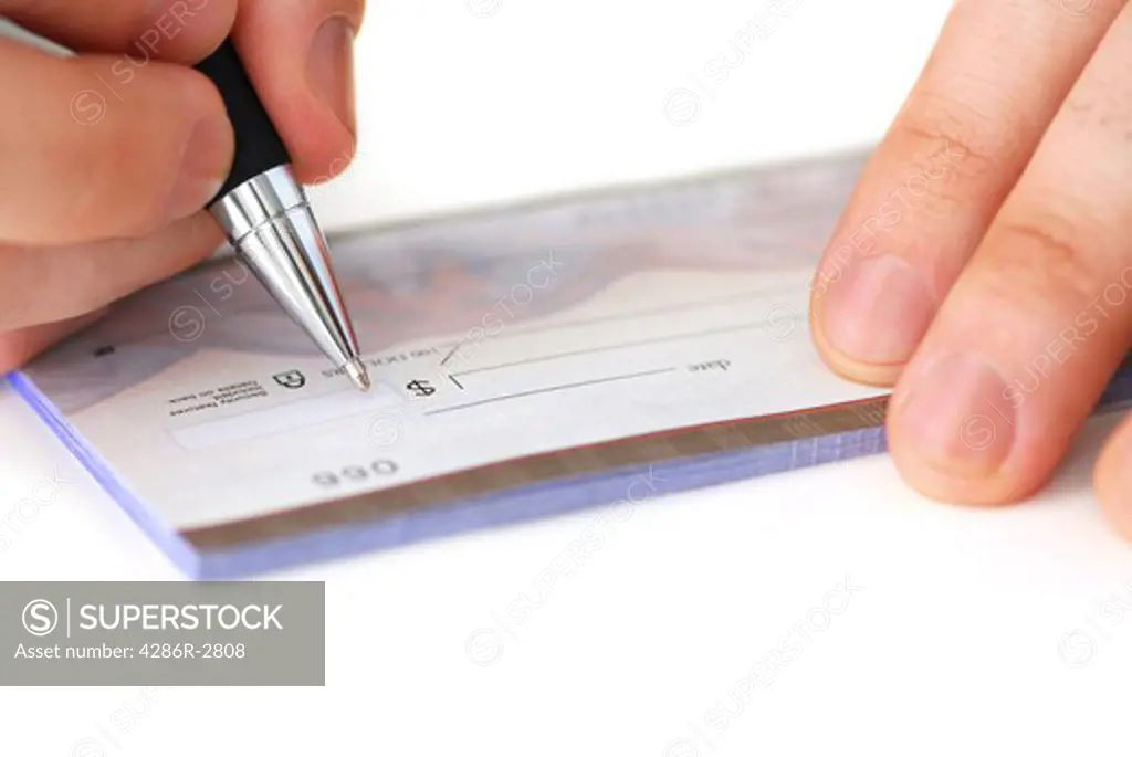 Closeup of man's hands writing a cheque