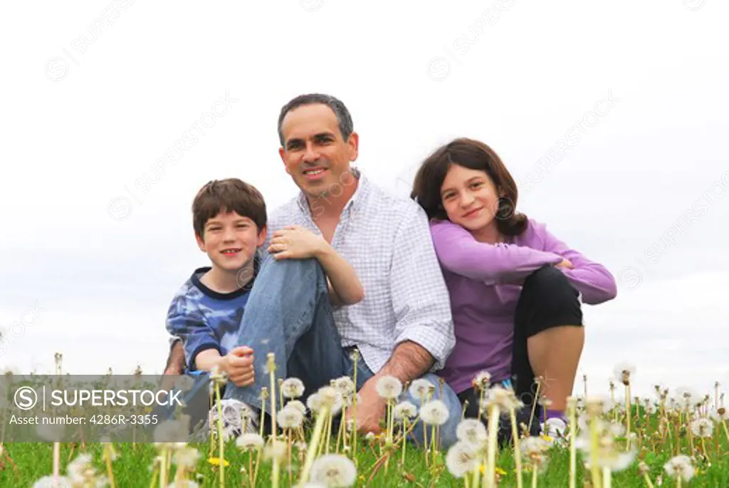 Portrait of a happy family of three on green grass