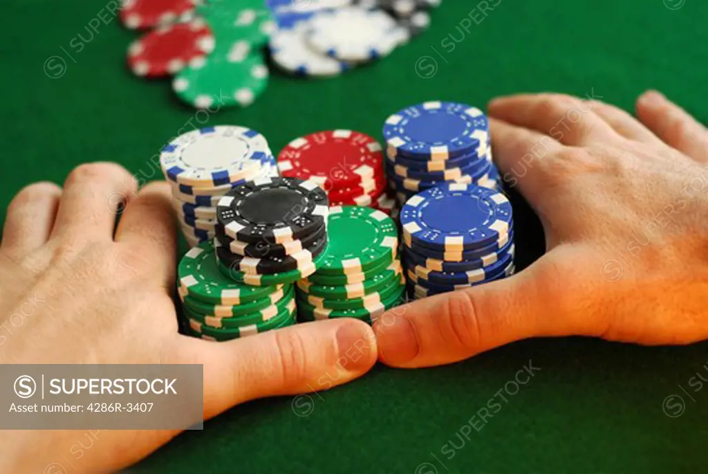 Poker player going 'all in' pushing his chips forward
