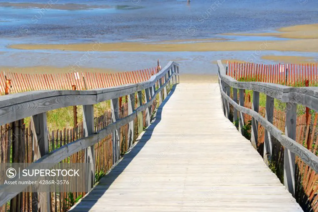 Wooden path over sand dunes with beach view