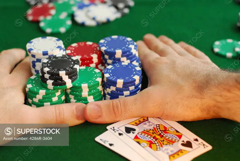 Poker player going all in pushing his chips forward
