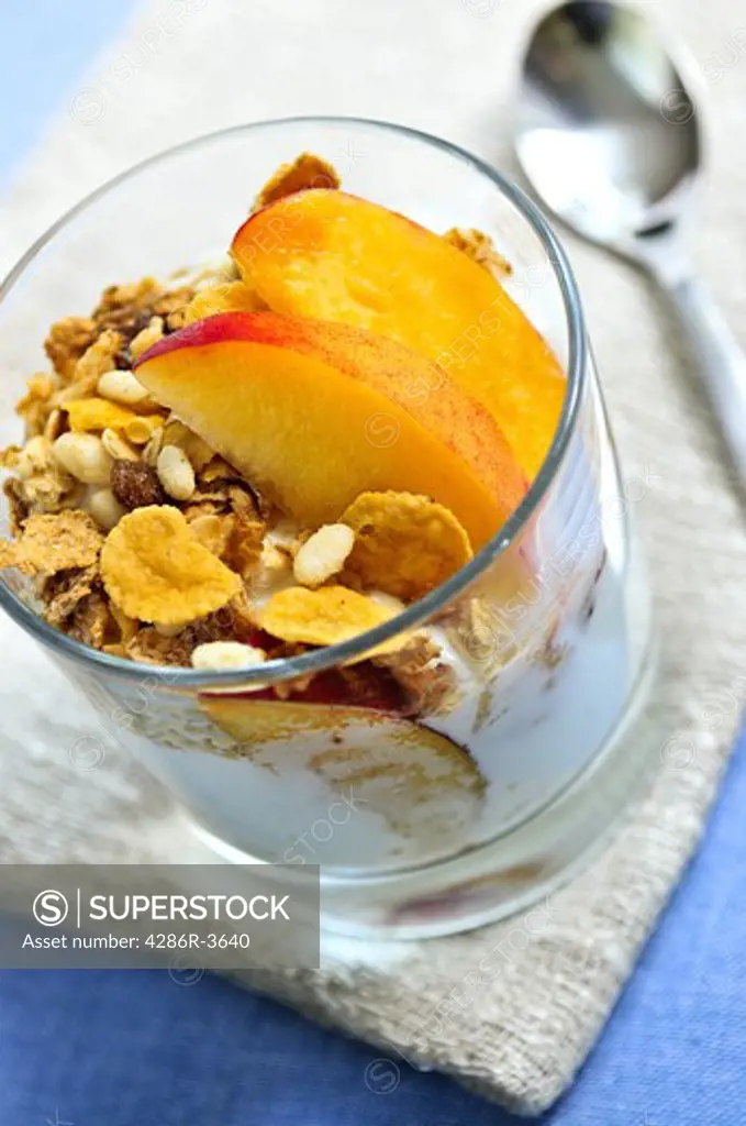 Serving of yogurt with fresh peaches and granola