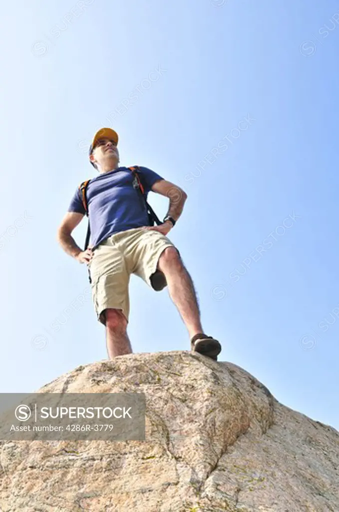 Middle aged hiker standing on top of a mountain