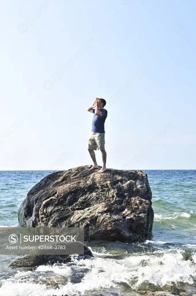 Man stranded on a rock in ocean calling for help