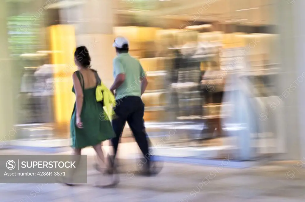 Couple shopping in a mall, panning shot, intentional in-camera motion blur