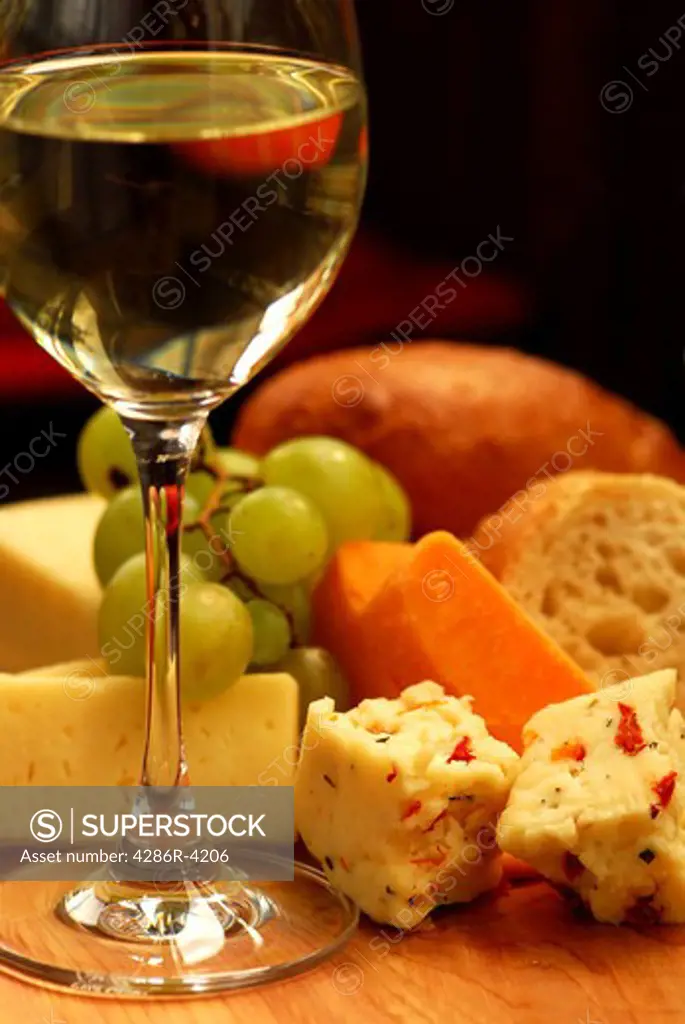 Glass of white wine and assorted cheeses for wine tasting