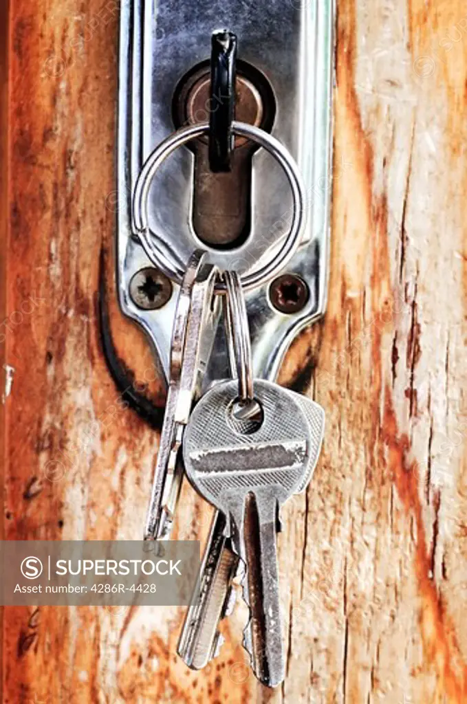 Set of keys in lock of old wooden door
