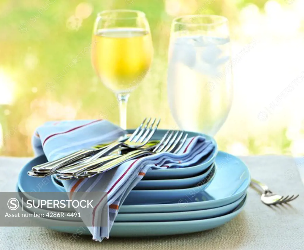 Table setting with stack of plates and cutlery