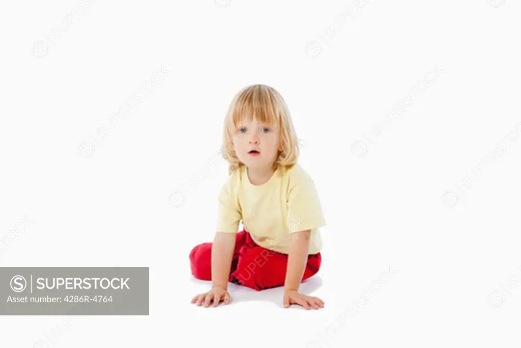 boy with long blond hair sitting on the floor-clipping path