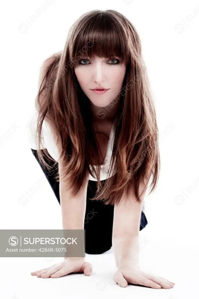 brunette with long hair crawling on the floor looking at camera isolated on white