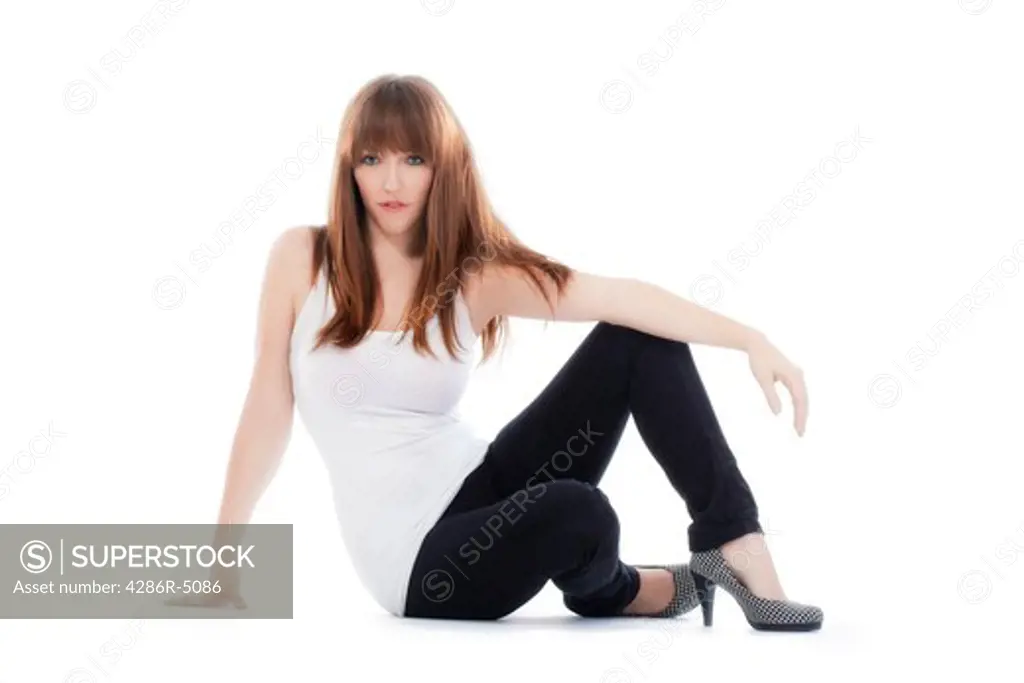 brunette with long hair sitting on the floor looking at camera isolated on white