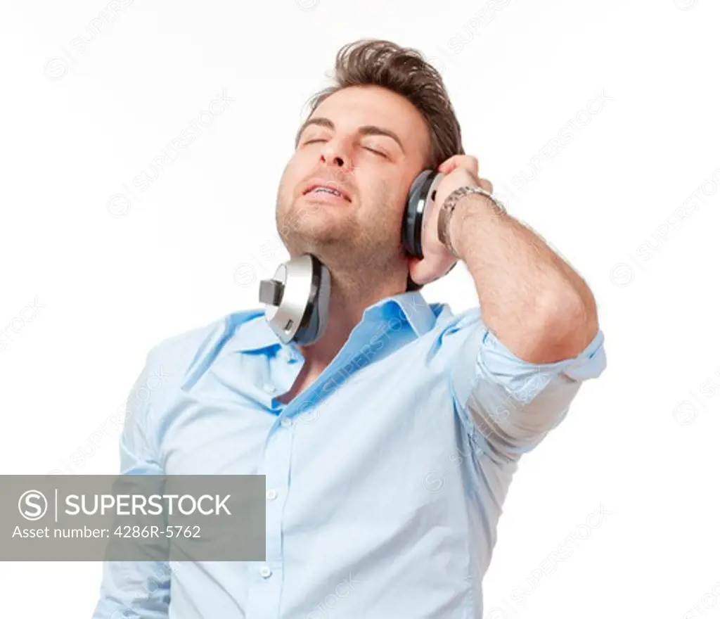 man in blue shirt with earphones listening to music - isolated on white
