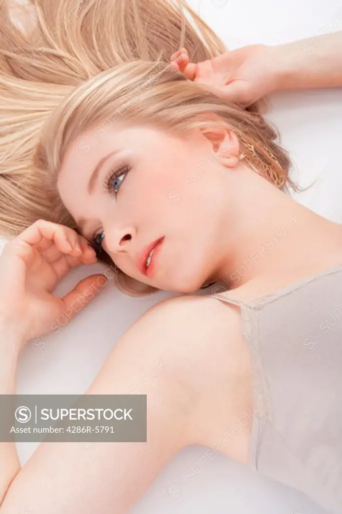 beautiful young woman lying down, looking- isolated on white