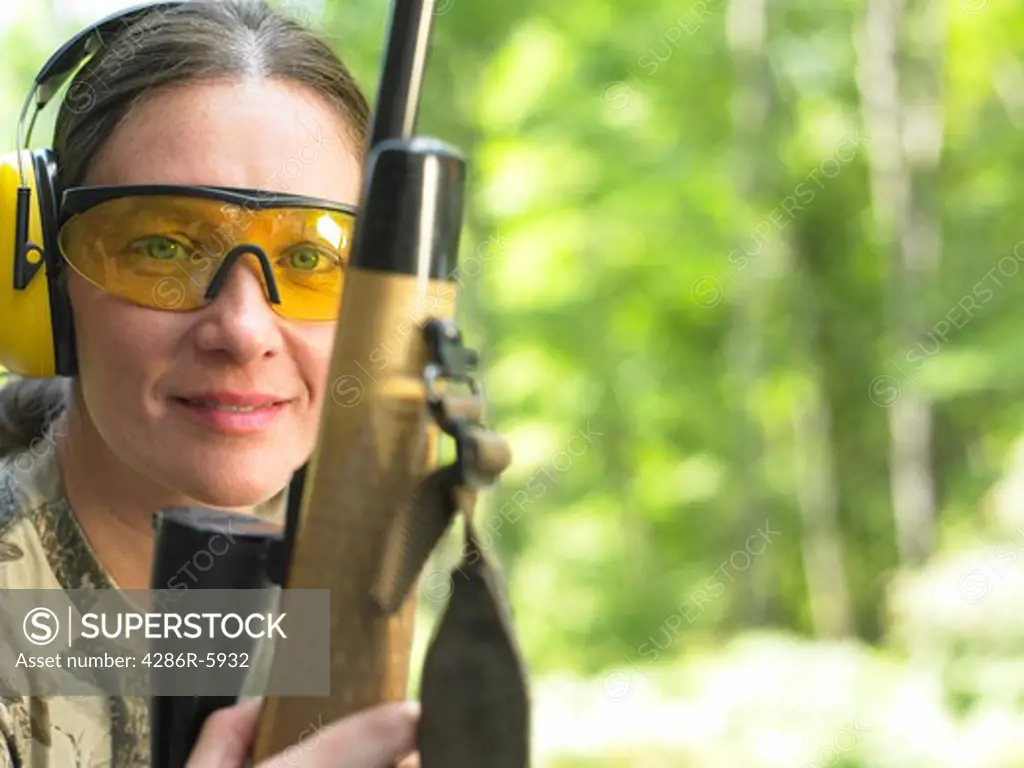 Close up portrait of a woman holding a high power hunting rifle  Property Release available.