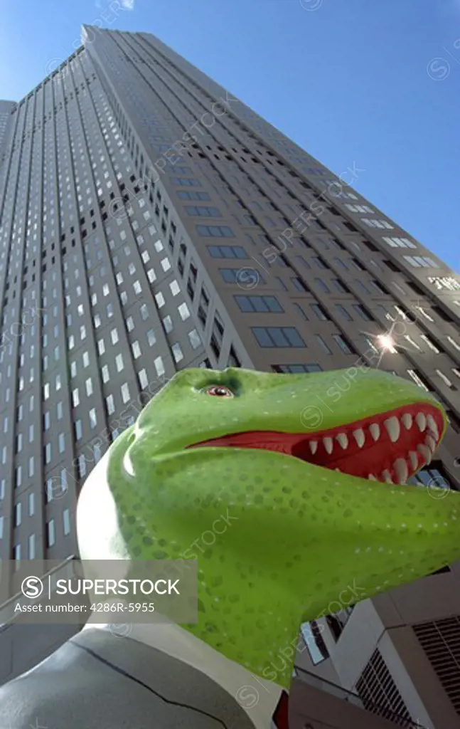 Sculpture of a dinosaur in business attire standing beneath a skyscraper in Pittsburg Pennsylvania