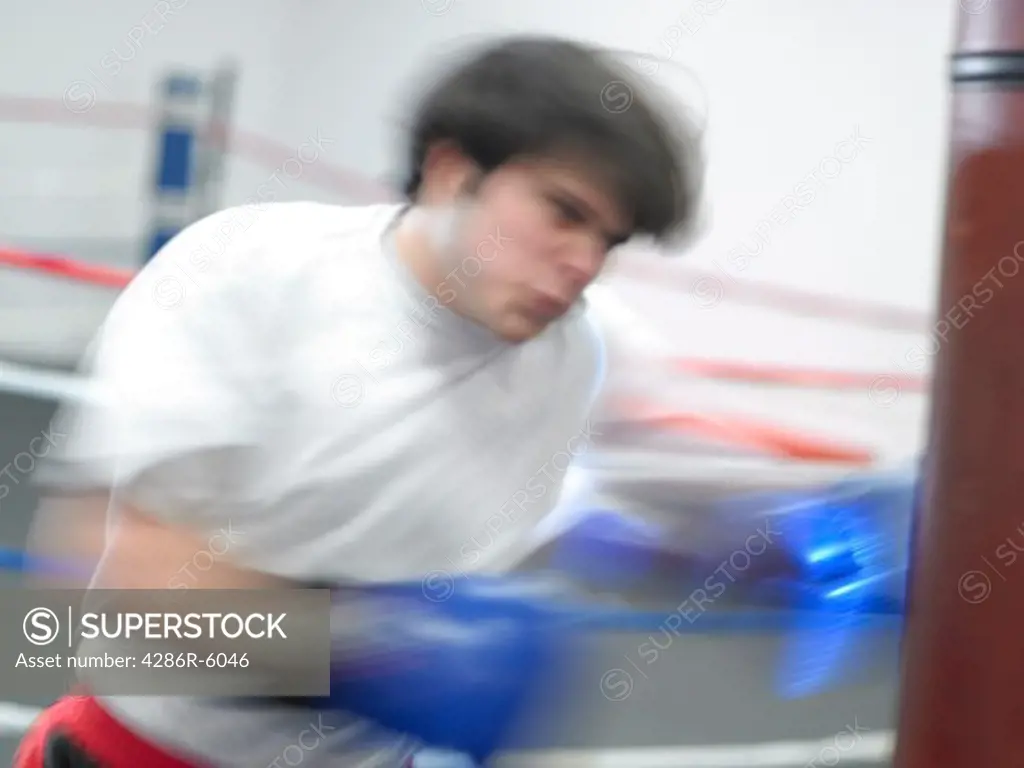 Young male adult punching a boxing bag