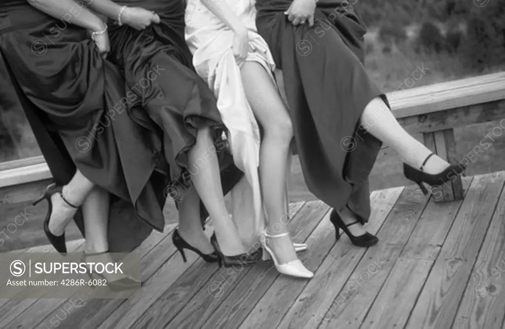 bride and bridesmaids showing legs for picture