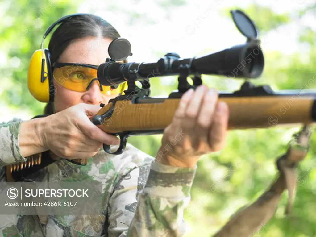 Medium close up of woman firing a high power rifle