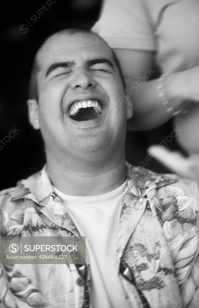 Black white Close up of young adult male in hawaiian shirt laughing
