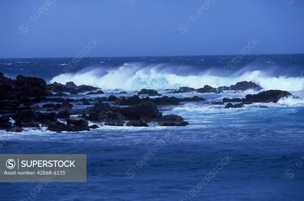 View from the beach along the Hana Highway showing waves crashing on rocks at Ho okipa beach in maui Hawaii