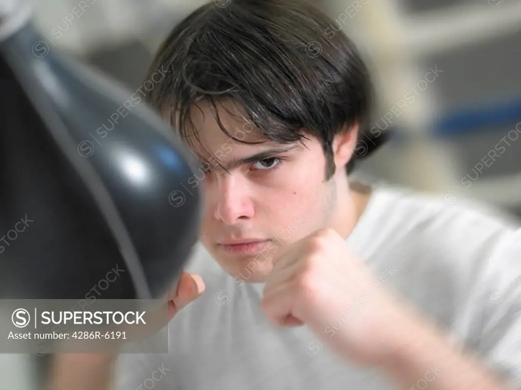 Young caucasian male fists up hitting bunching bag