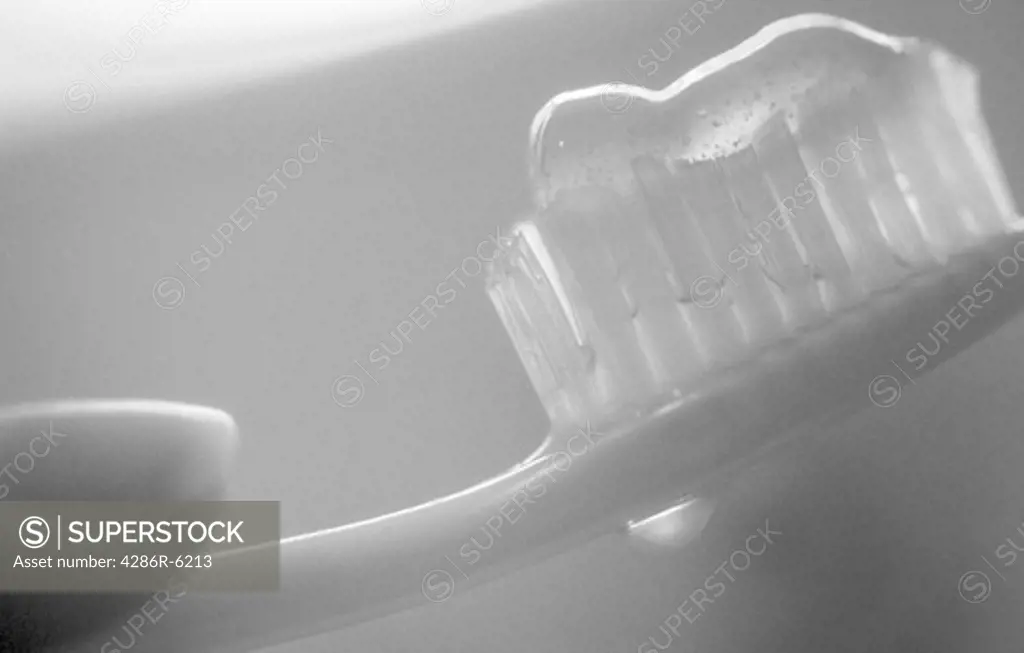 Hand griping a toothbrush preparing to brush teeth