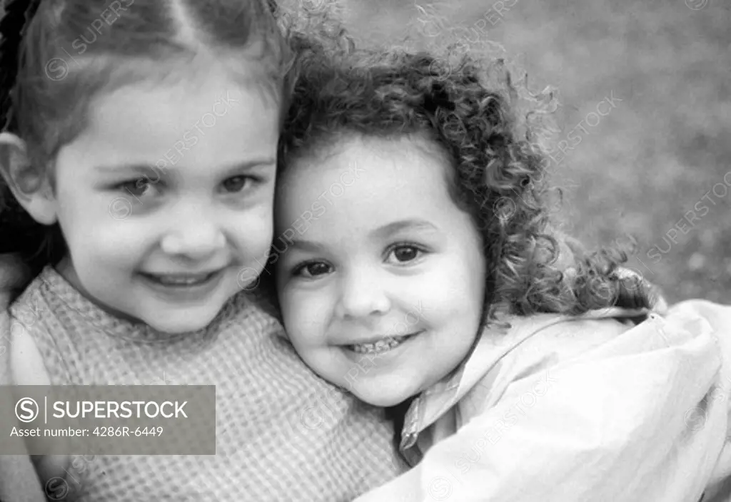 Close up of two adorable little hispanic girls hugging