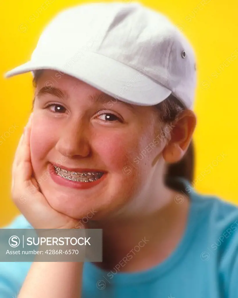 Vertical portrait of a smiling teenage girl wearing braces on her teeth.