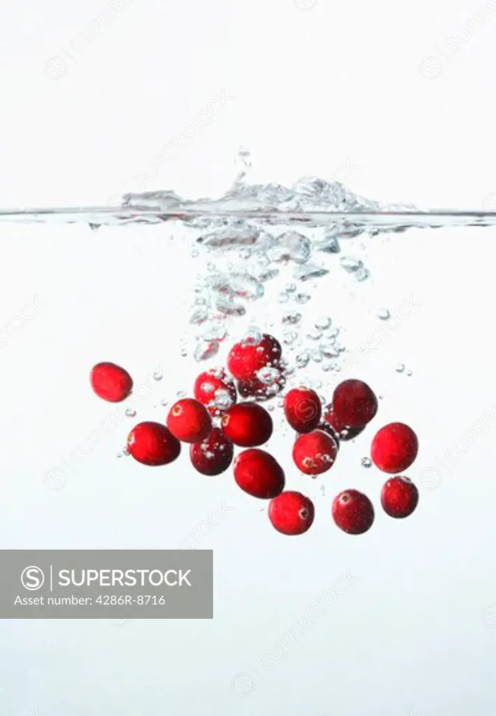 Cranberries splahing into water