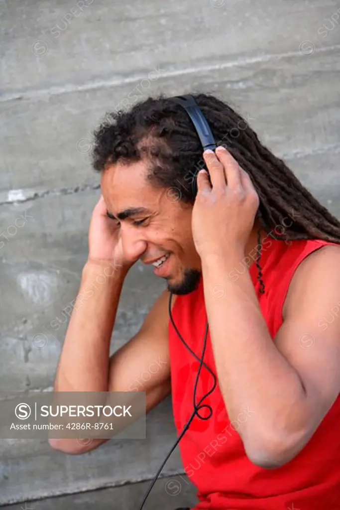 Young man with dreadlocks listening to music