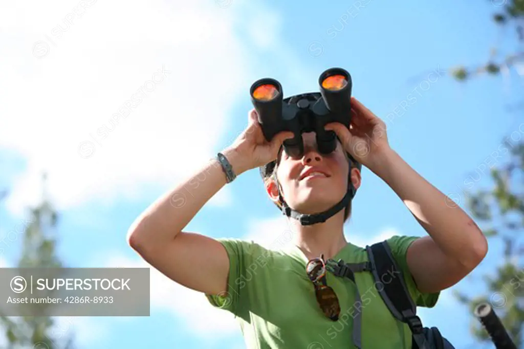 Woman outdoors looking through binoculars