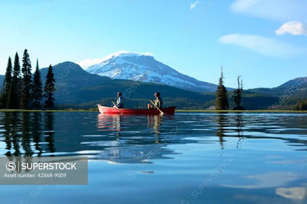 Couple paddling canoe on lake