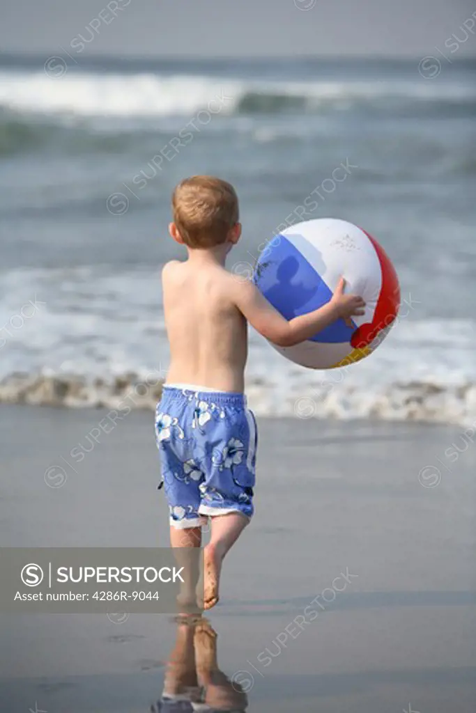 Young boy at the beach with beach ball